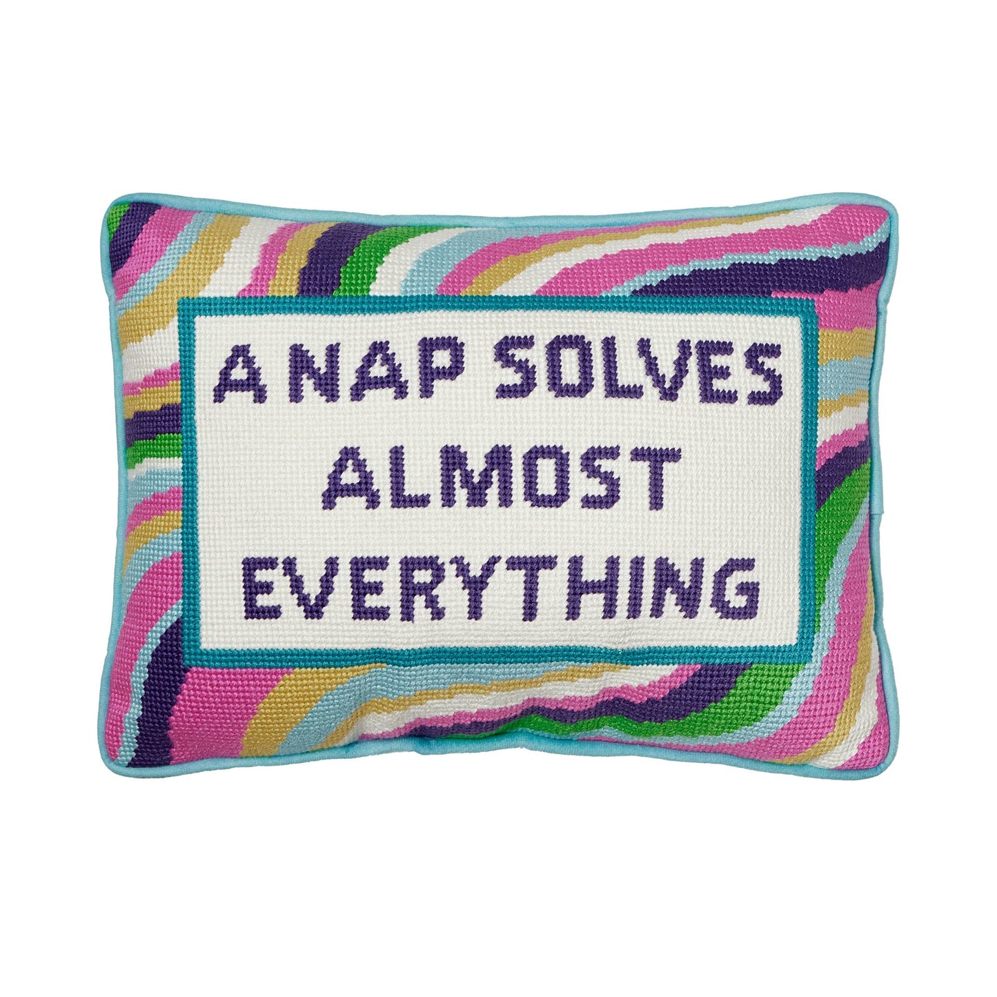 Swirly, multicolored pillow with framed novelty needlepoint text “A Nap Solves Almost Everything”