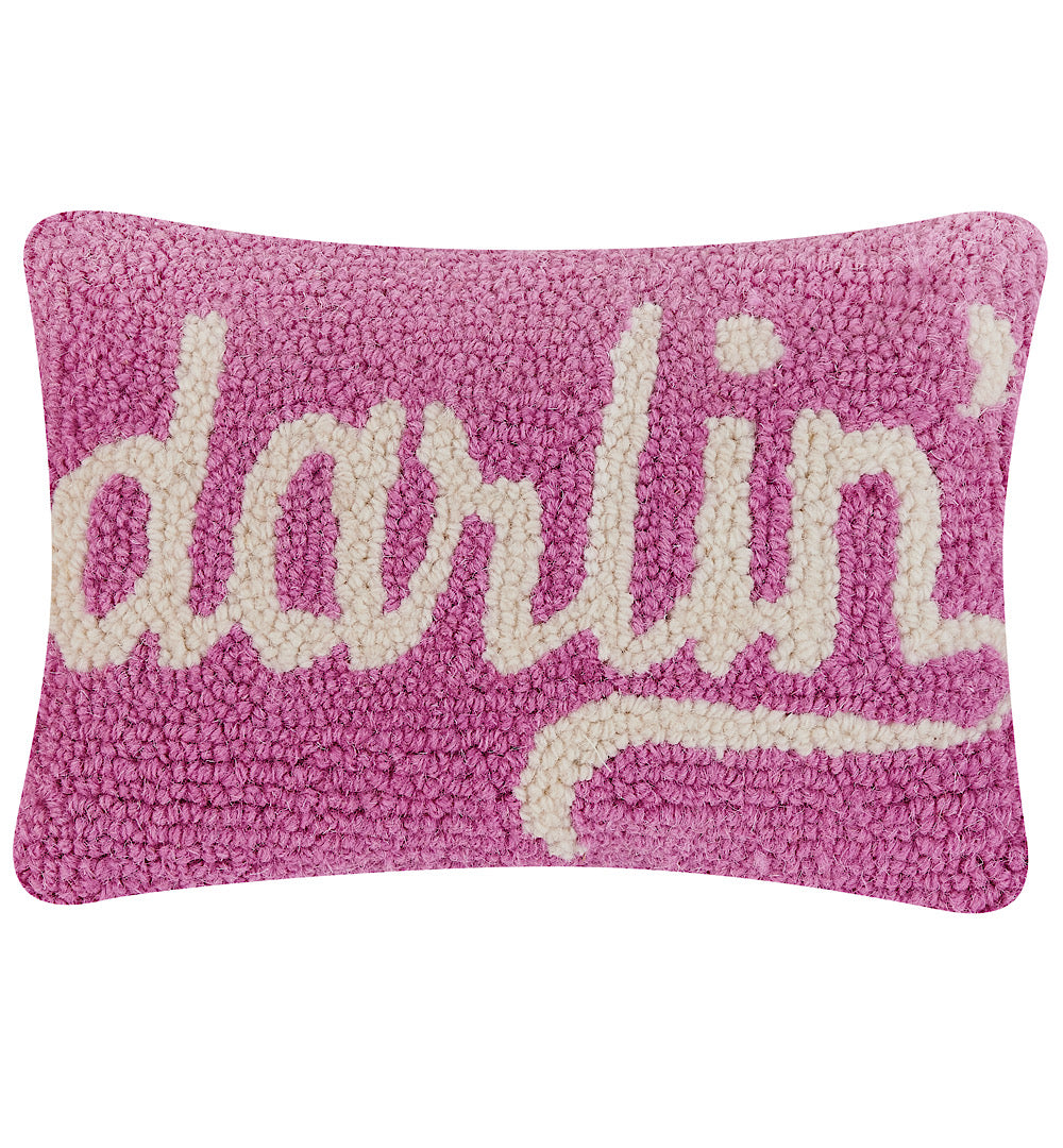 Wool hooked pink lumbar shaped pillow with “darlin’” in white cursive letters.
