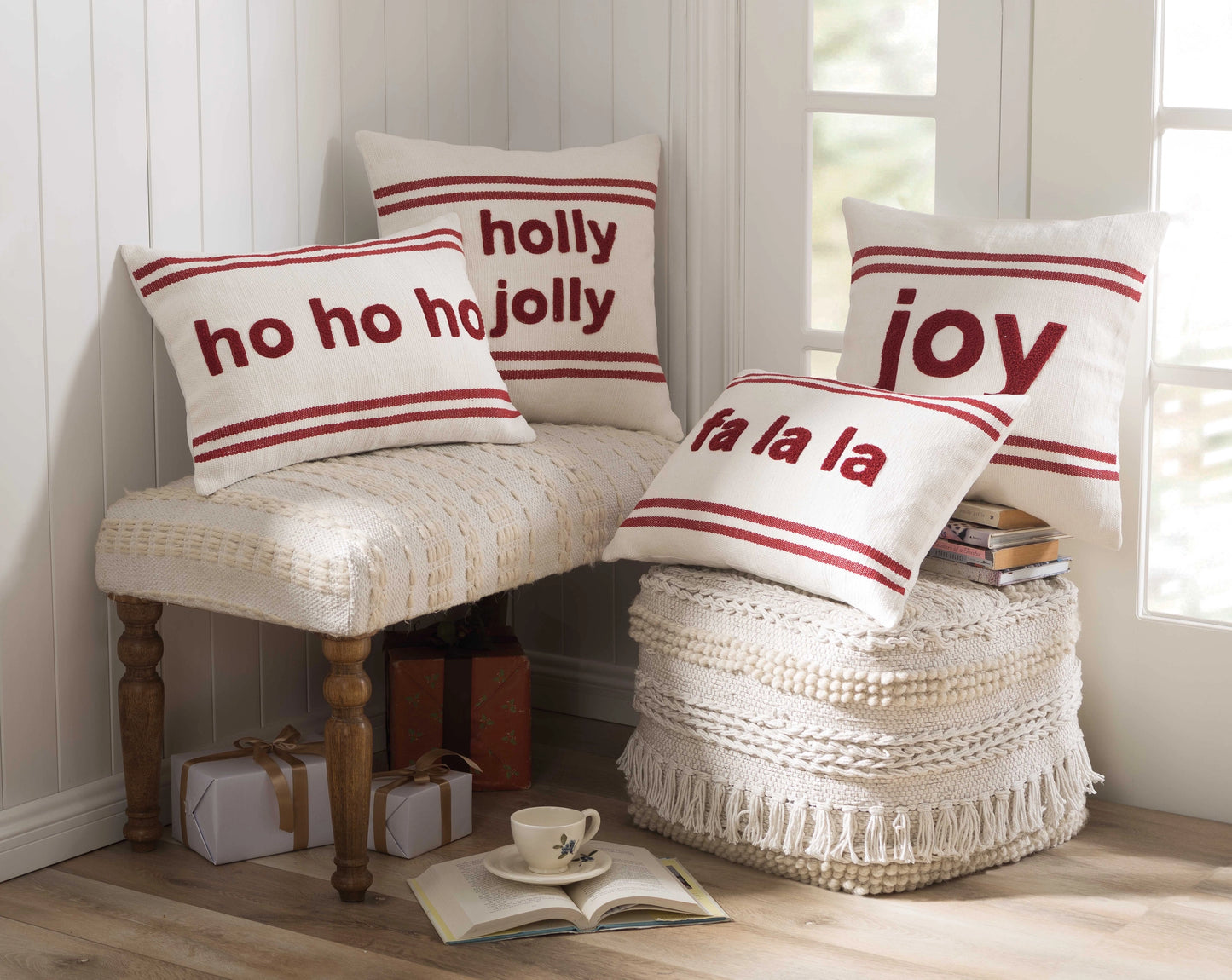 Home corner with various red and white holiday pillows on cream colored stools.