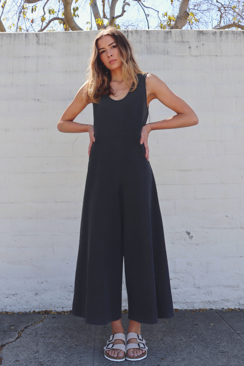 Sleeveless, flowy jumpsuit with waist defining seam and wide legs for flexible wear. Fabric is organic cotton in vintage ash black color.