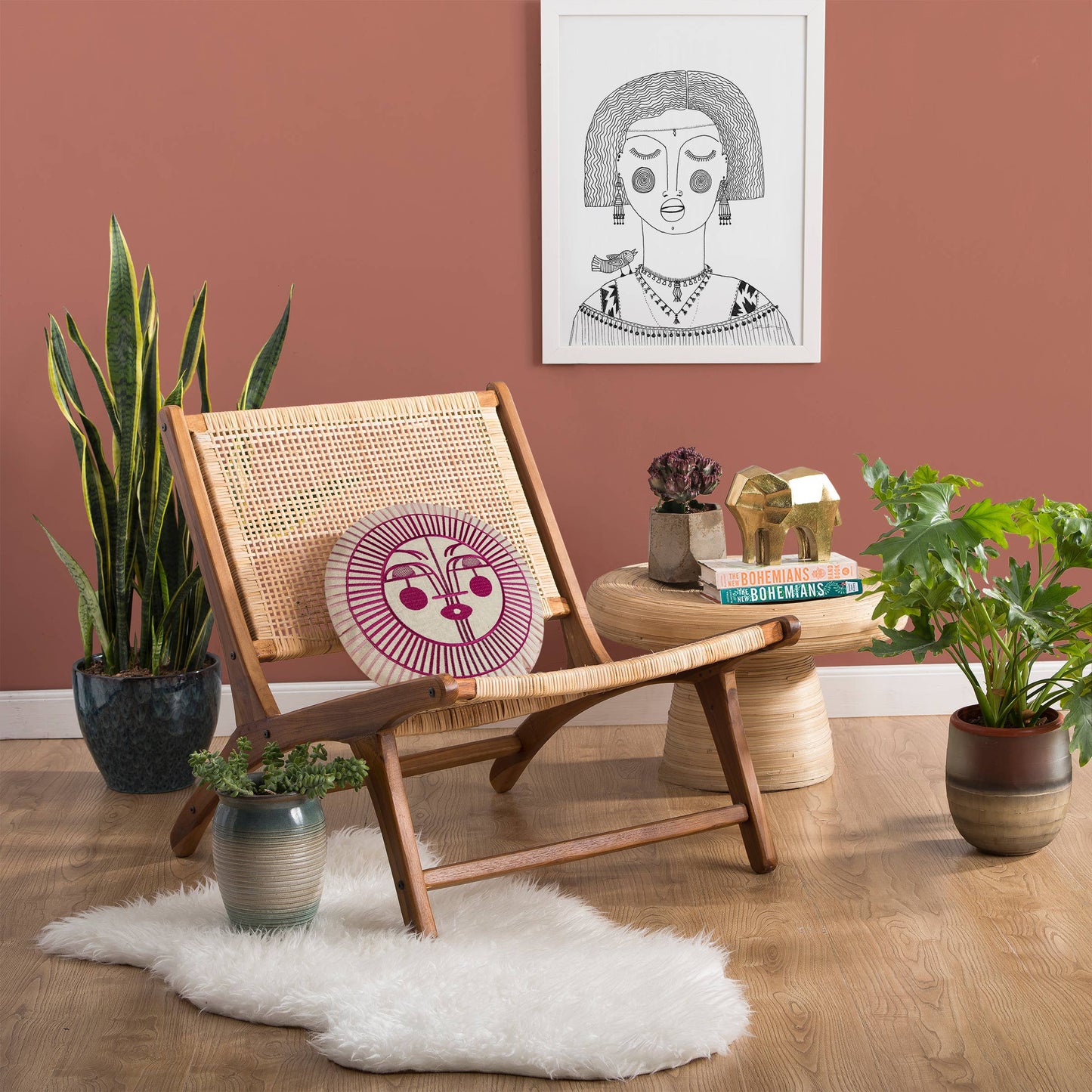 Complementary boho accent pillow with pink and red sun design that can be layered with other home decor