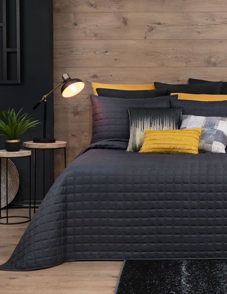 Contemporary bedroom with black bedding and quilted embroidery.