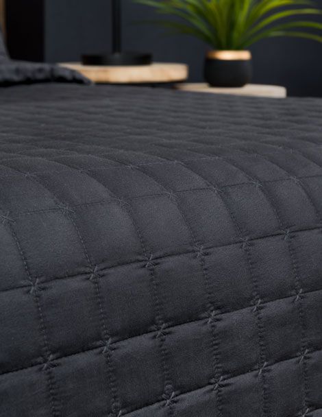 Detailed view of adult quilted bedding in all black.