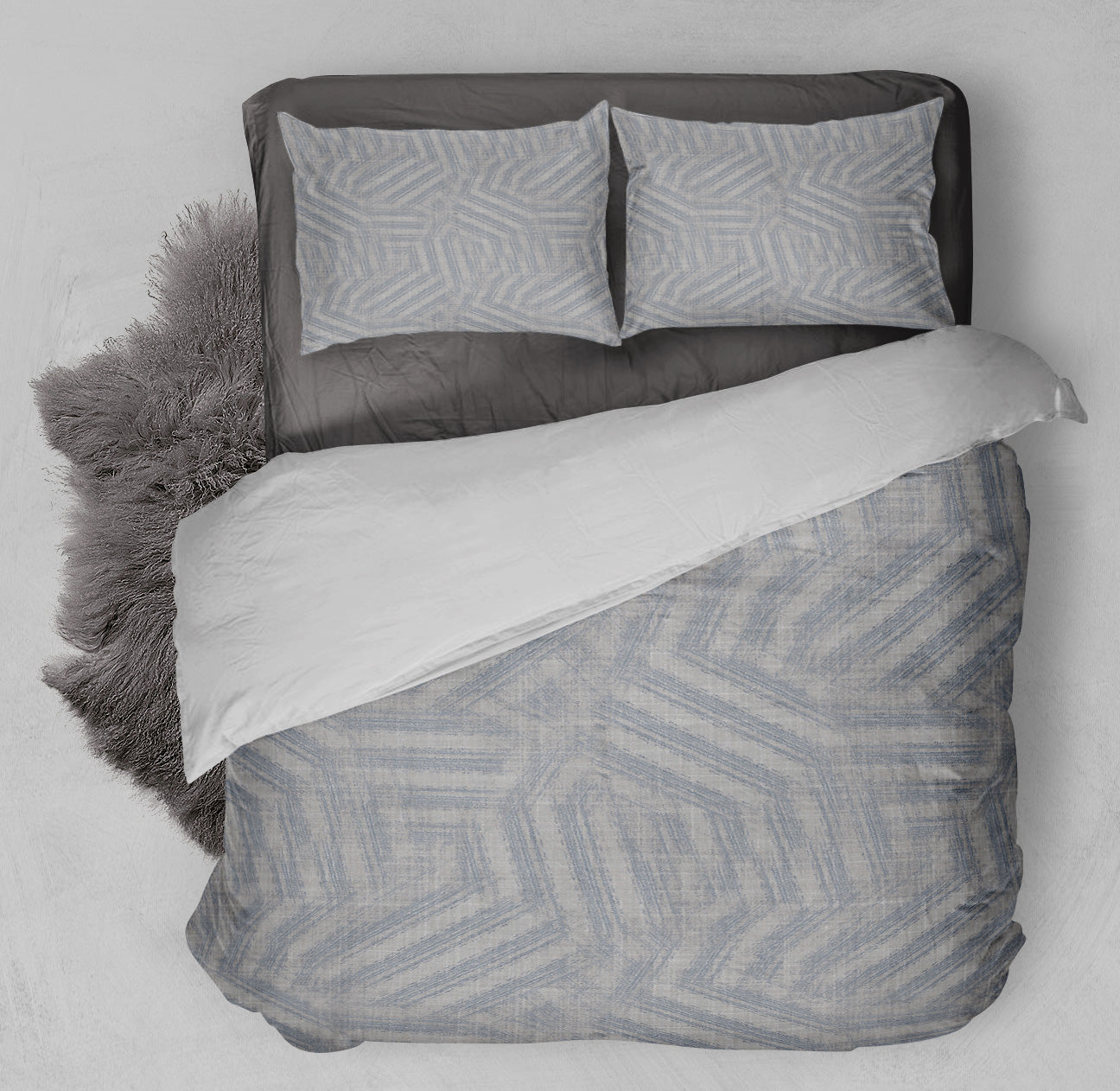Clean bed featuring printed gray comforter set with captivating blue maze pattern and complementing gray shag rug.