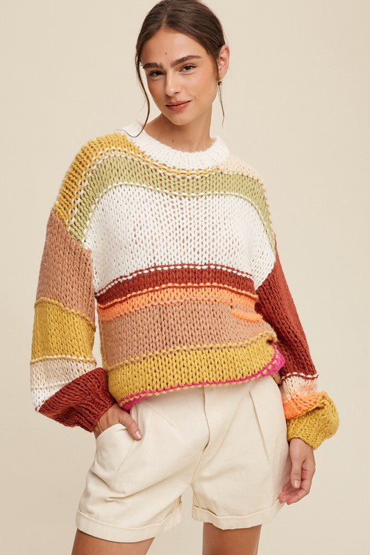 Open knit crochet pattern sweater with unstructured earth tone stripes of yellow, brown, white, green and peach.