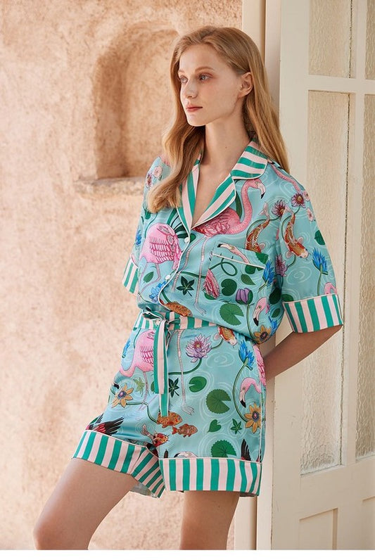 Lounging Pajamas Shorts Set with Light blue background and multicolor, tropical  theme. Light pink and green striped collar and edges.