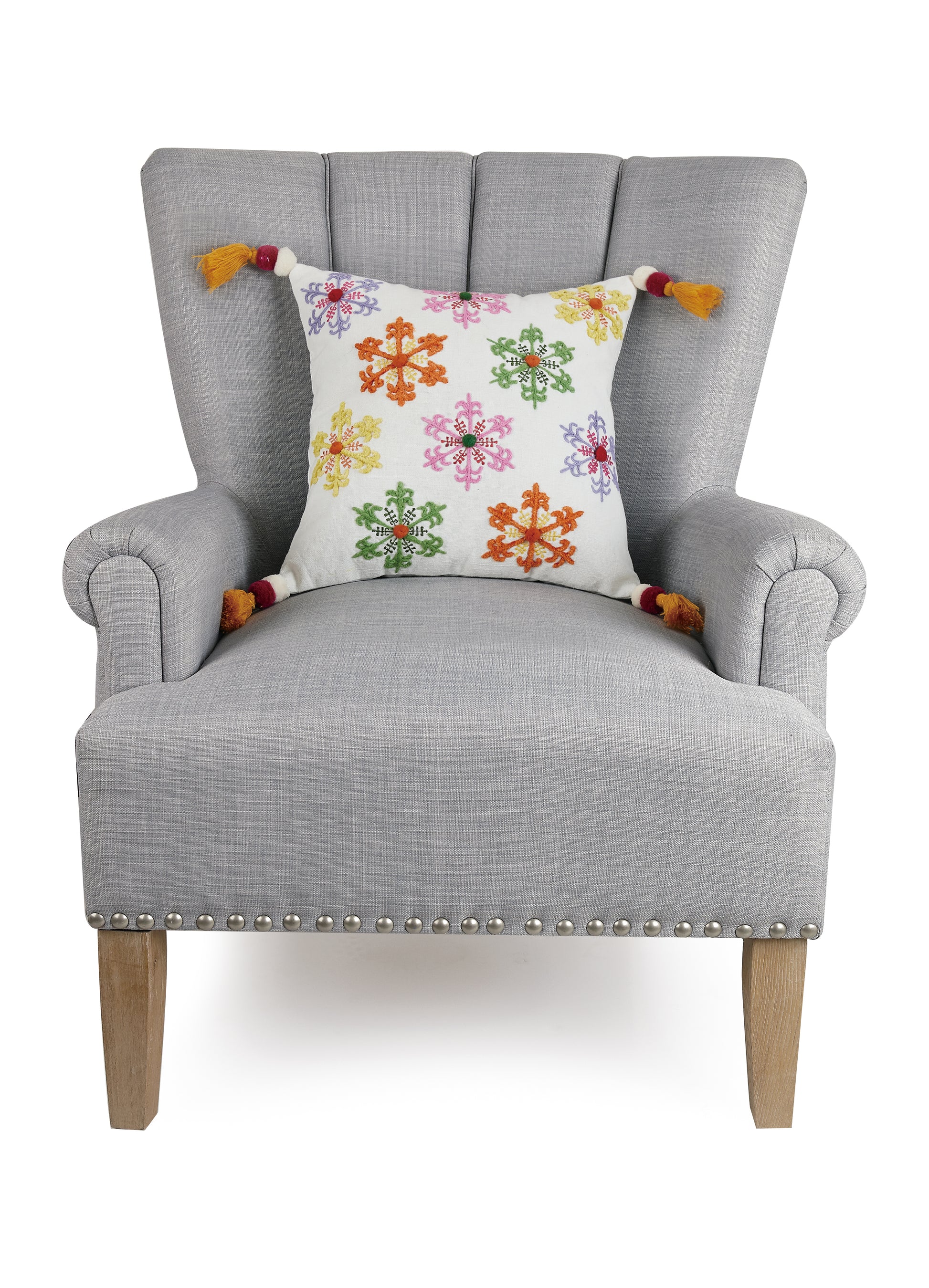 Gray accent chair styled with embroidered snowflake tassel pillow