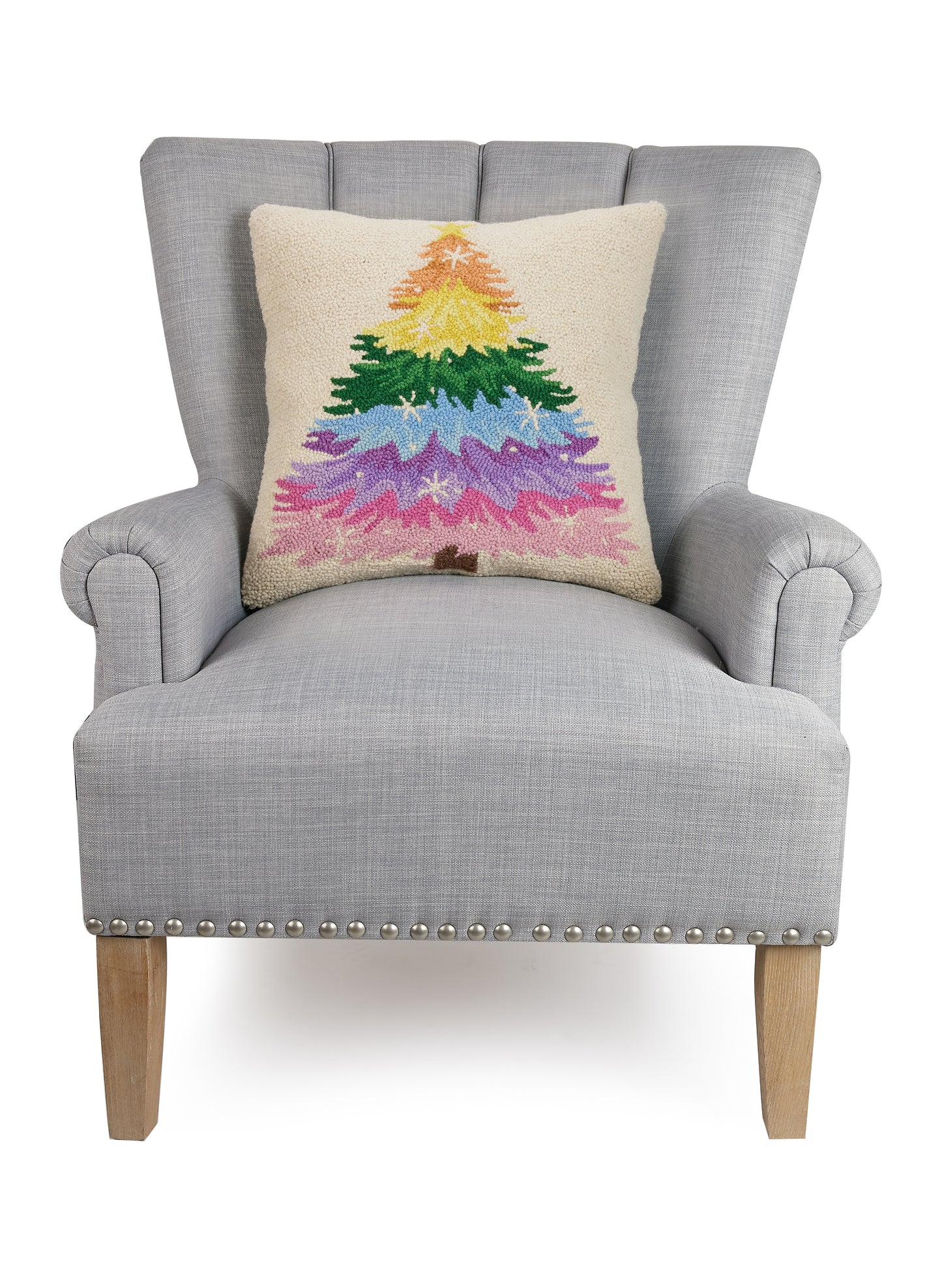 Dazzling rainbow Christmas tree pillow styled with gray sitting chair