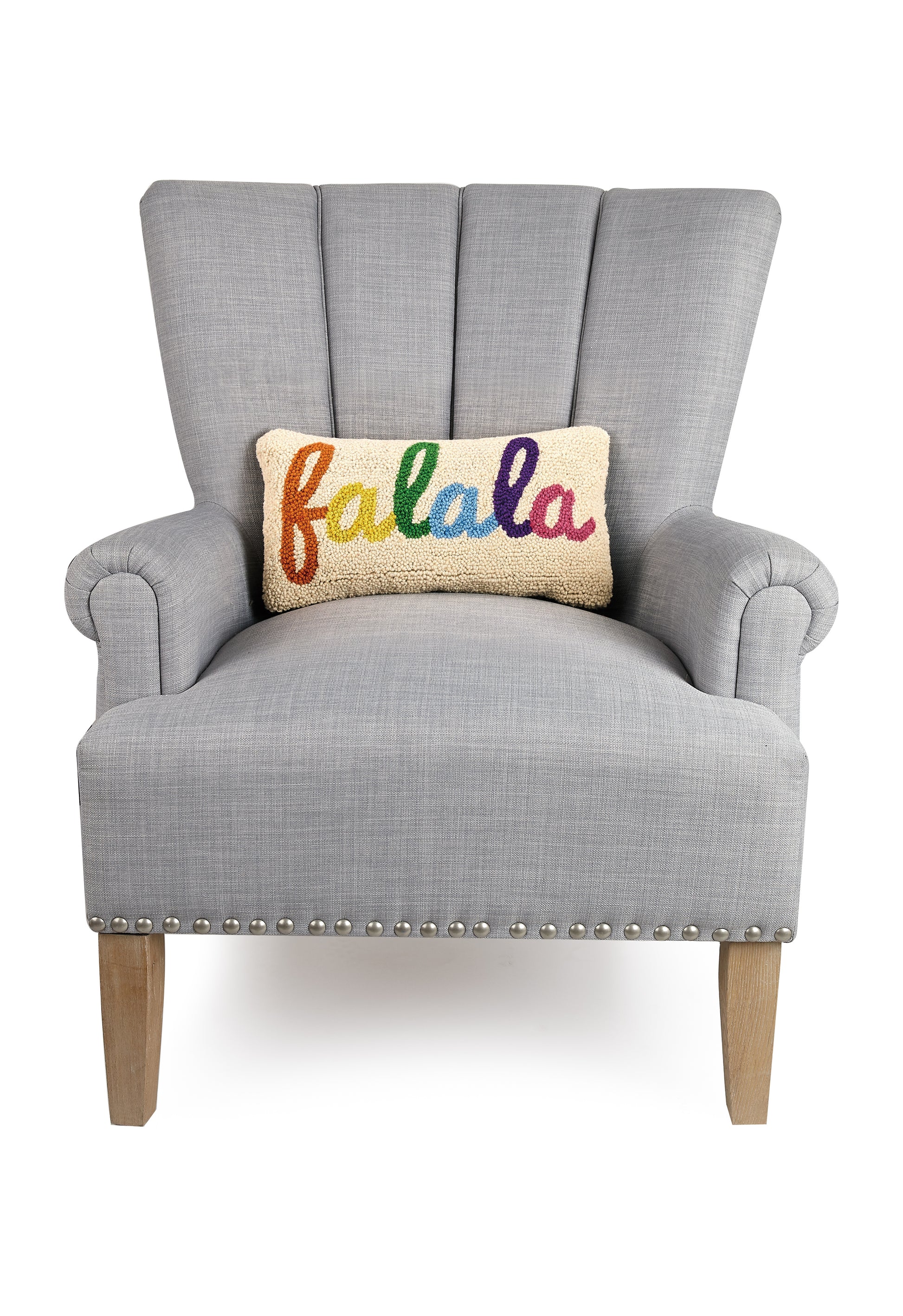 Classic gray upholstered chair featuring wool holiday pillow that reads, “fa la la” in rainbow colors