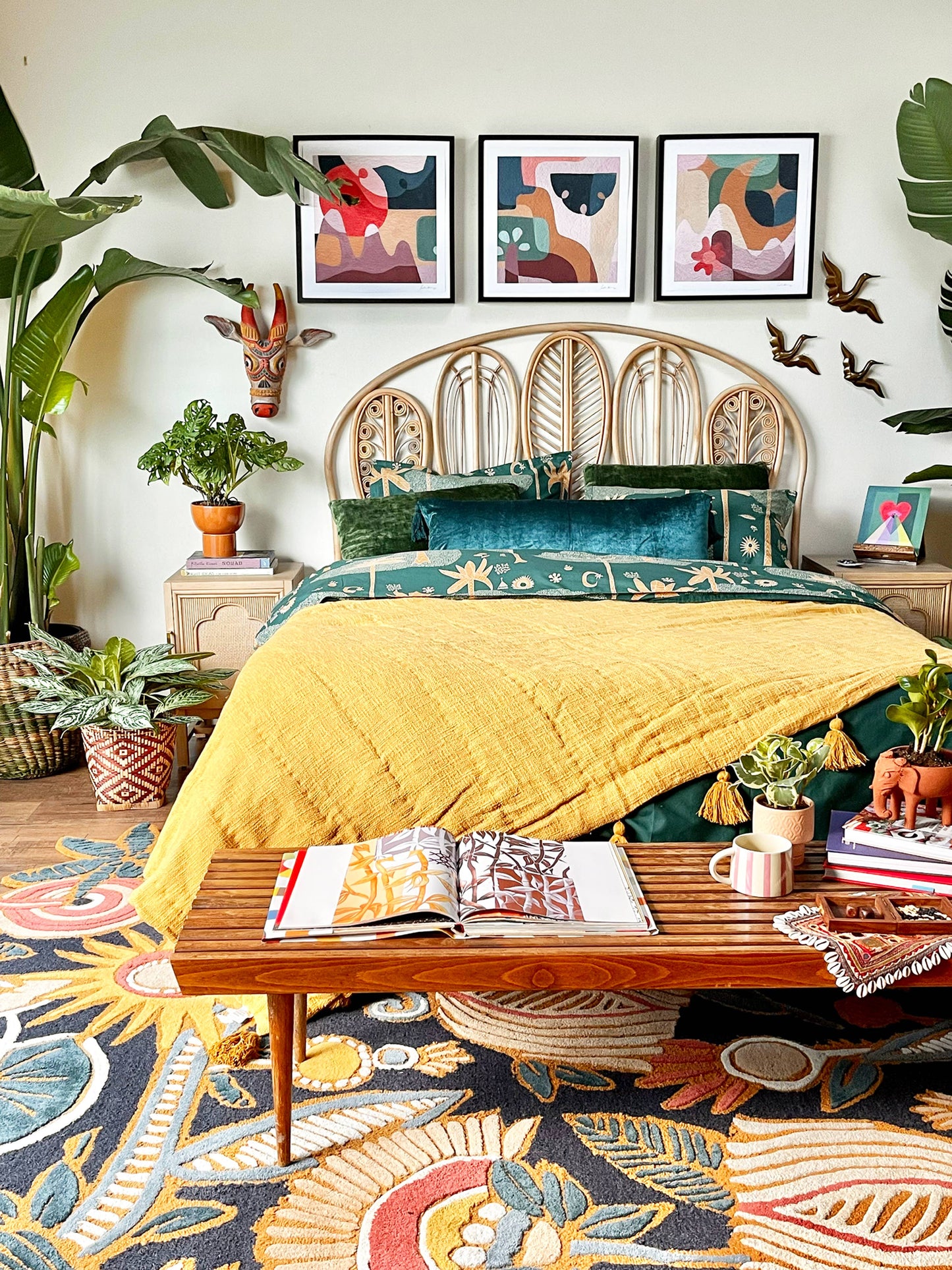 Eclectic boho room decor with yellow tassel quilt layered with green Cosmic Duvet adorned with palm tree motifs.