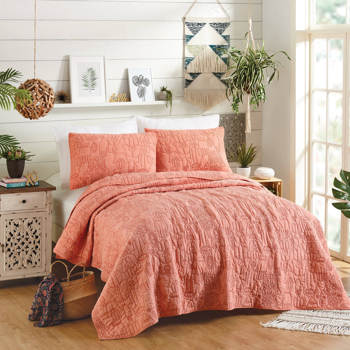 Boho style room with peach colored quilt adorned stitched Hand of Fatima motifs.