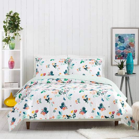 Modern room with reversible floral quilt featuring soft shades of turquoise, mint and pink.