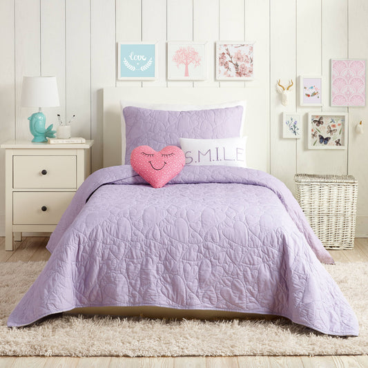 Youth bedroom featuring lavender quilt with detailed heart-shaped stitching 