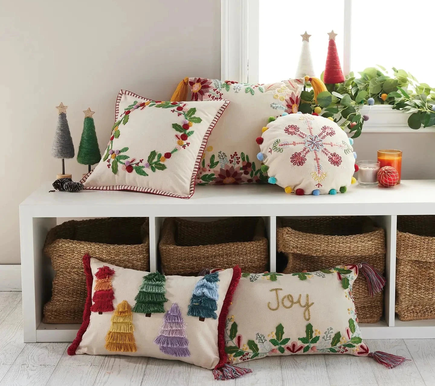 Holiday pillow display featuring multicolored Boho Snowflake Embroidered Pillow with Pom Poms and tasseled Boho Floral Holiday Pillow