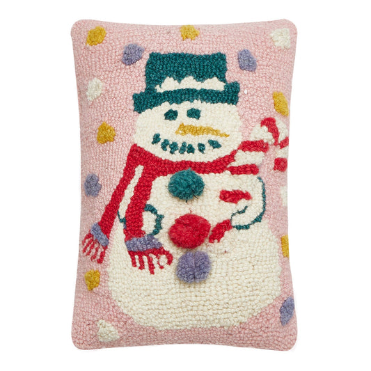 Decorative seasonal pillow with a snowman design and pom pom buttons on a pink background