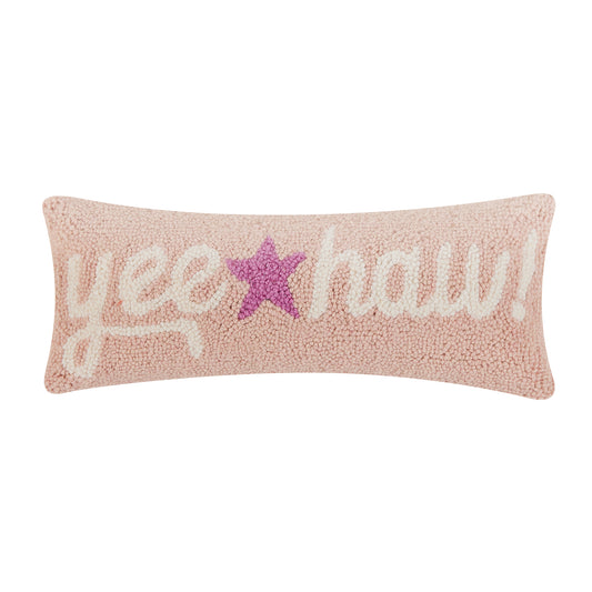 Soft pink wool hooked lumbar shaped pillow with “yee haw! In white cursive letters and purple star in the middle