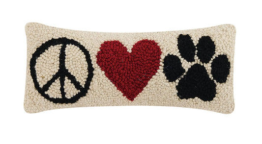 Cream wool hooked pillow with black and read motifs symbolizing the phrase “peace, love and paws.”
