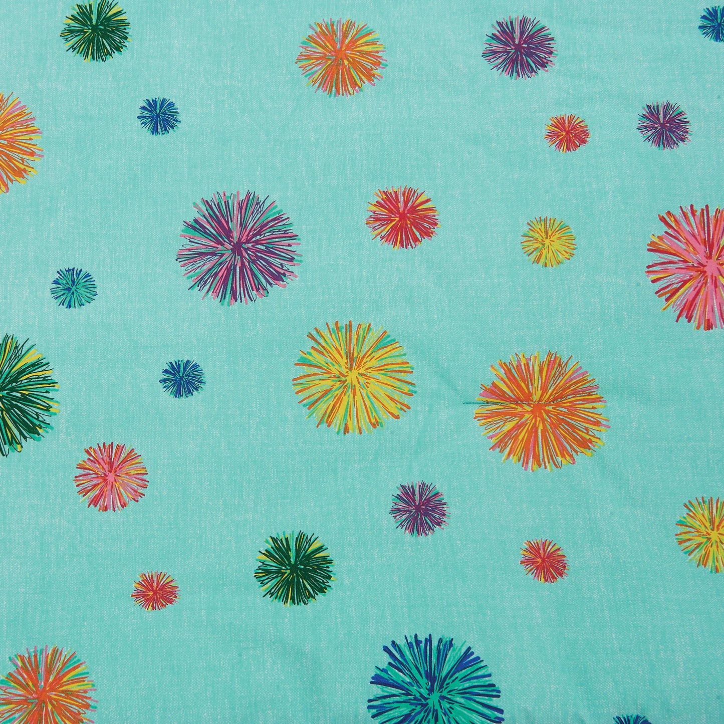 Close up of multi-colored poms across a turquoise spread