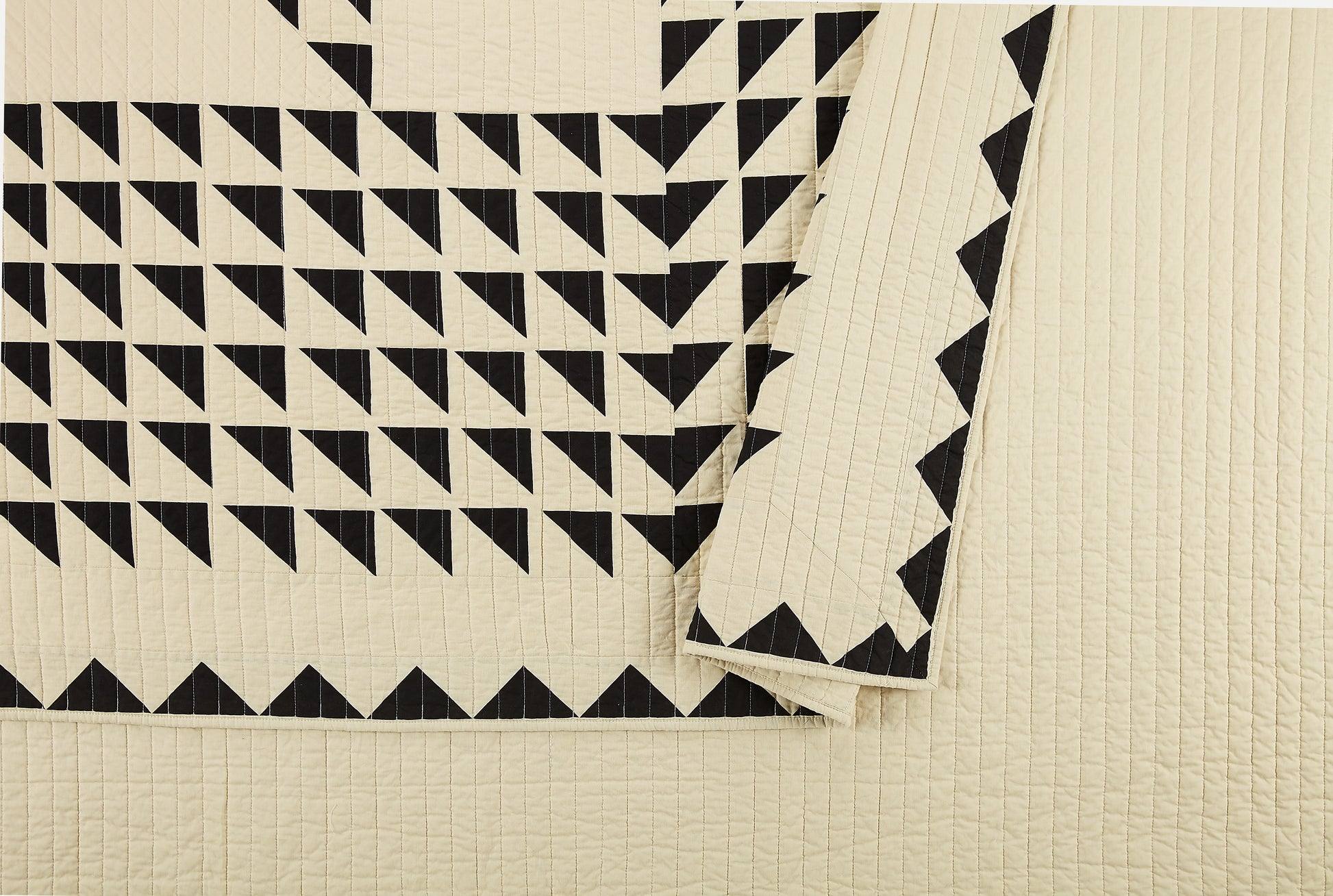 Close up of Lemieux Et Cie geometric, black and ivory quilt