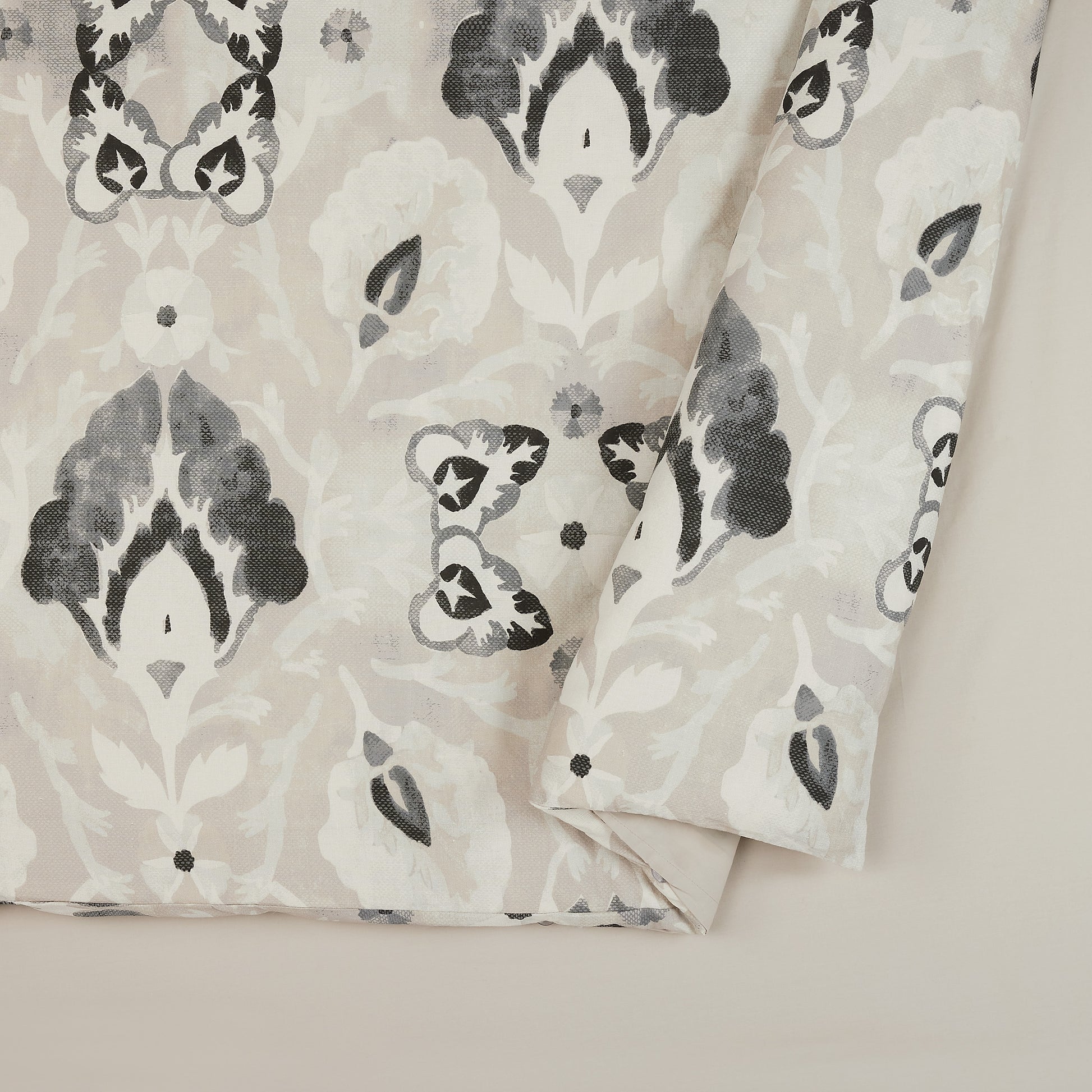 Close up of Lemieux Et Cie gray, black and cream duvet cover with floral motif pattern.