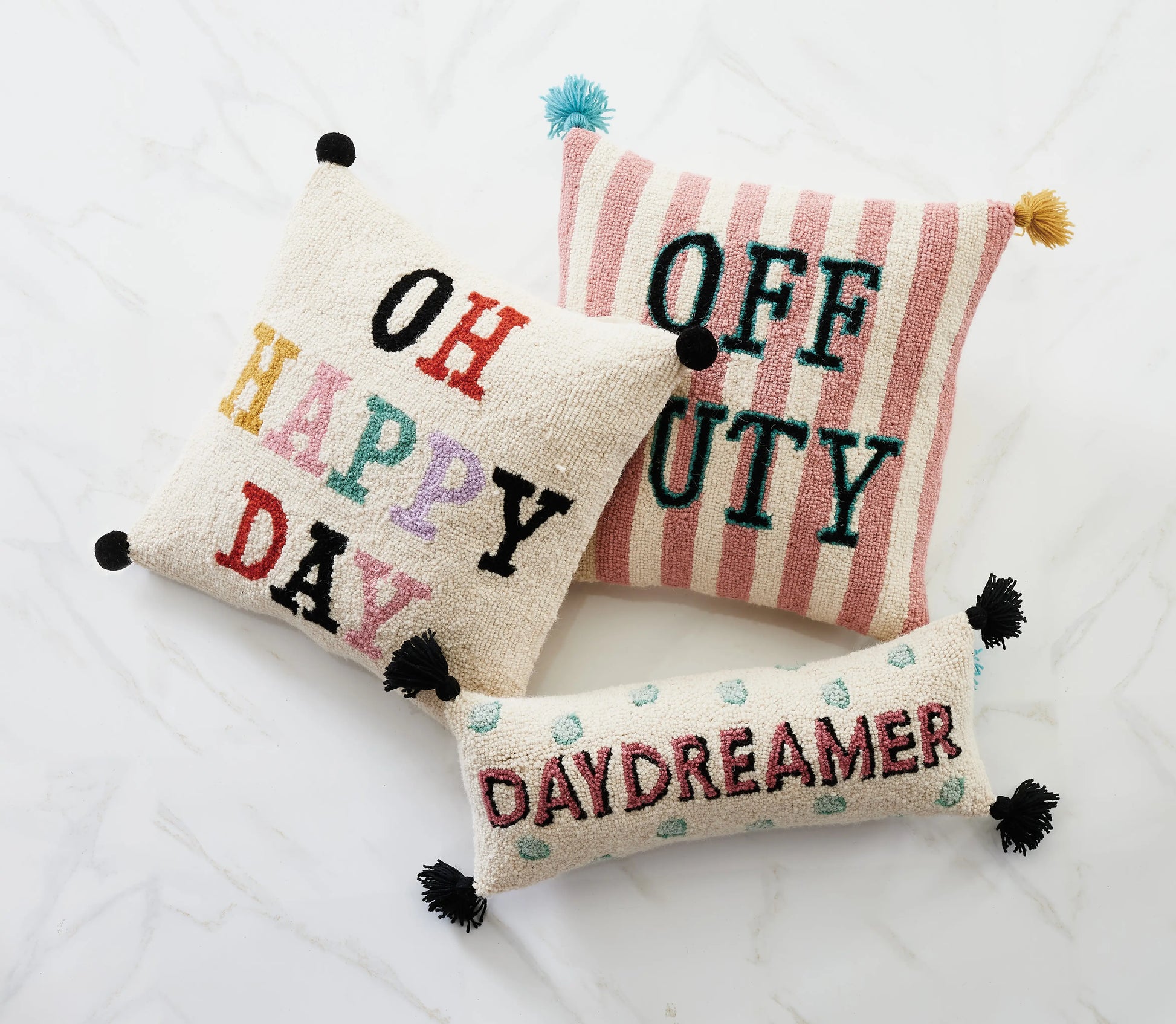 Assortment of multi-colored, graphic throw pillows by Yvonne Ellen: “Daydreamer,” “Oh Happy Day” and “Off Duty.”