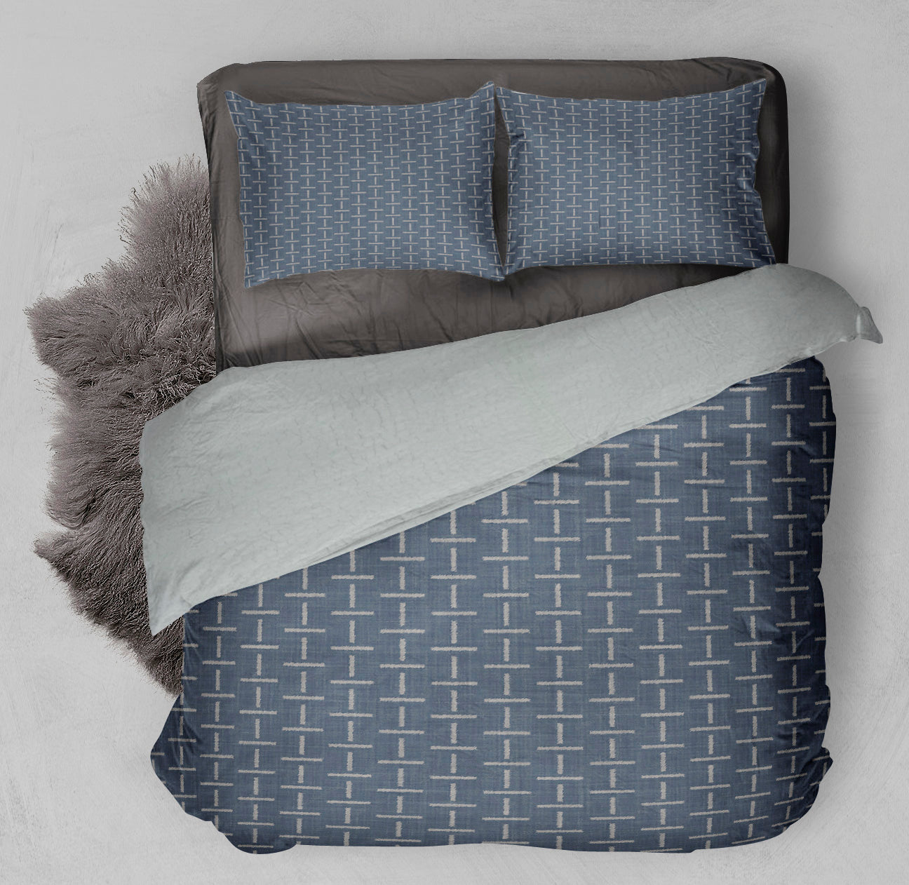 Cozy bed featuring winter ready Sherpa comforter, in chambray, with cross motifs throughout. 
