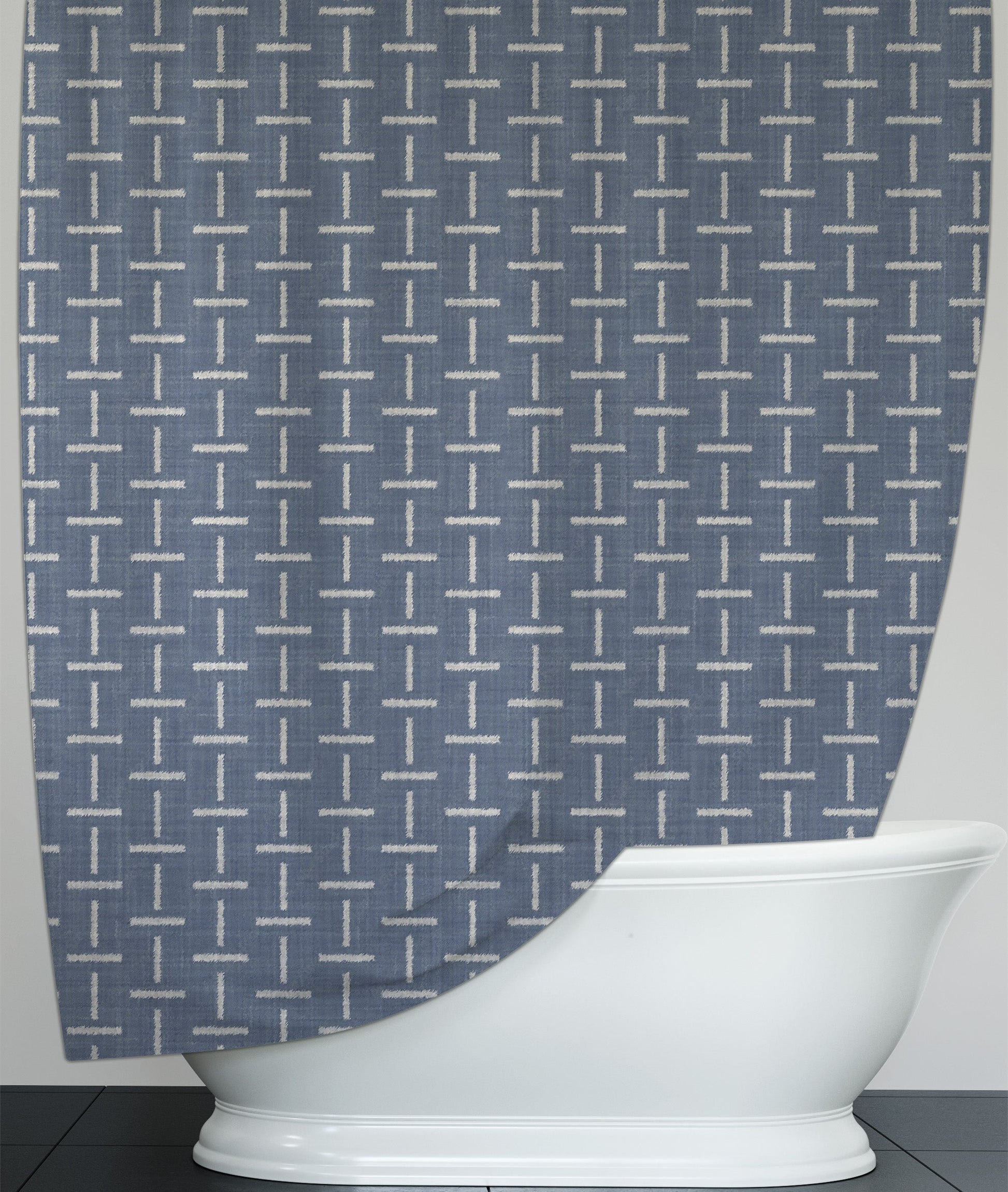 Soft blue printed shower curtain with intersecting white line design, hanging over pedestal bathtub 