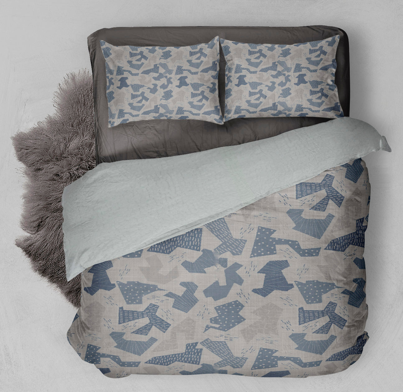 Bed featuring printed gray duvet comforter set with gray and blue abstract shapes.