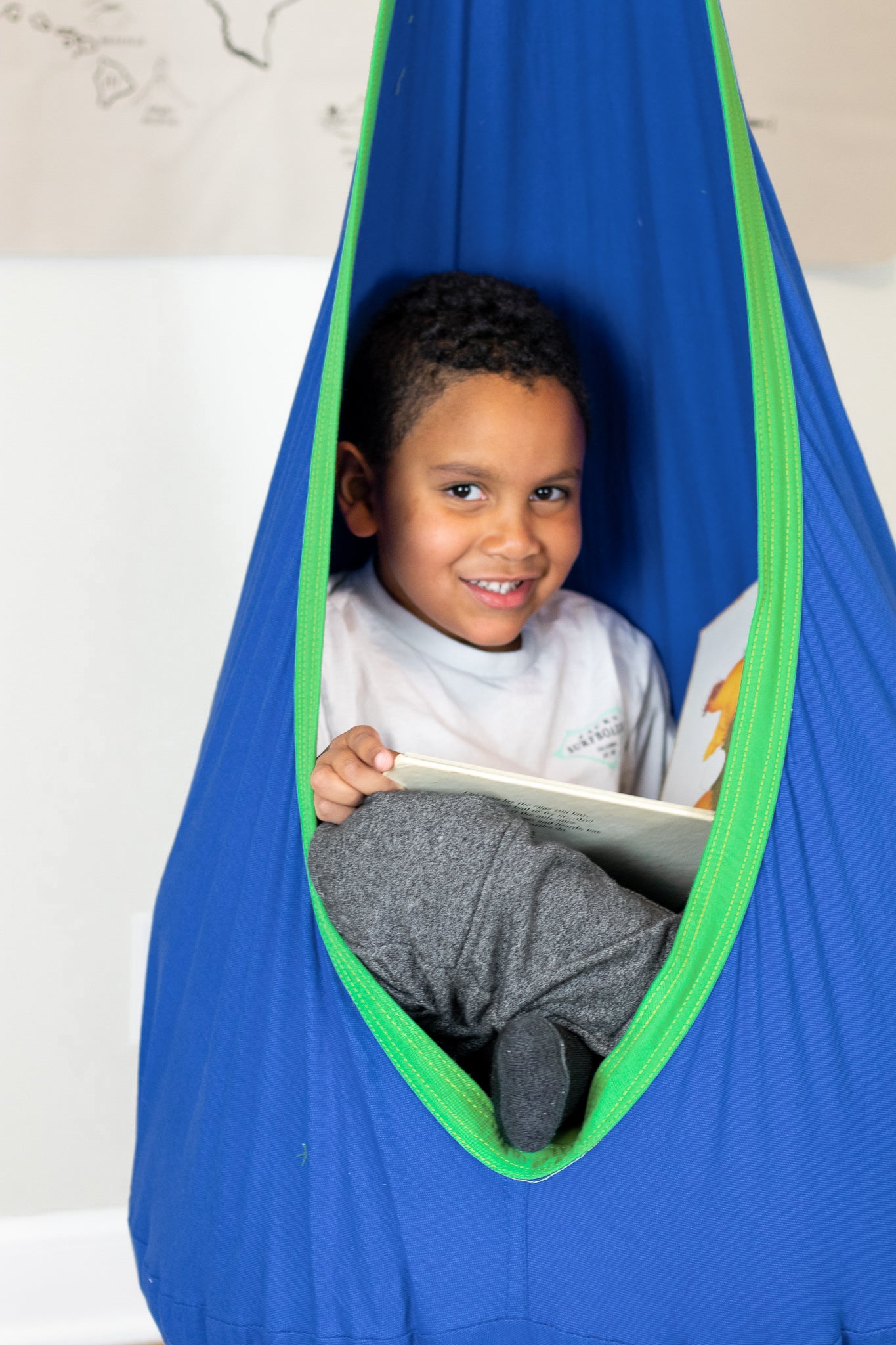 Boy smiling in comfy Calming Cove Sensory Swing.