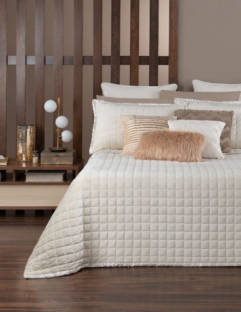 Contemporary bedroom featuring ivory bedding with quilted embroidery.