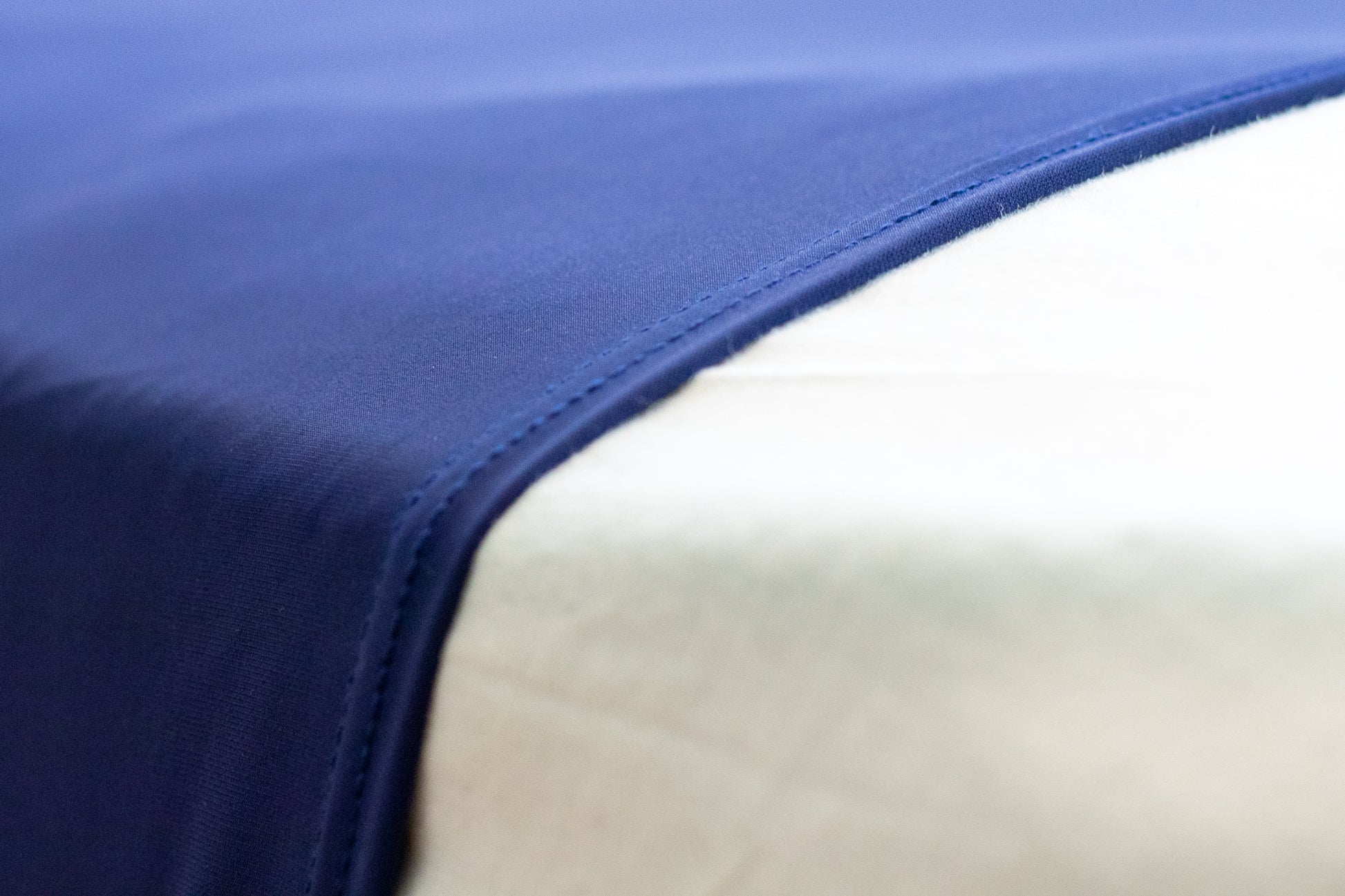 Close up view of blue compression bedsheet over white bed linen.