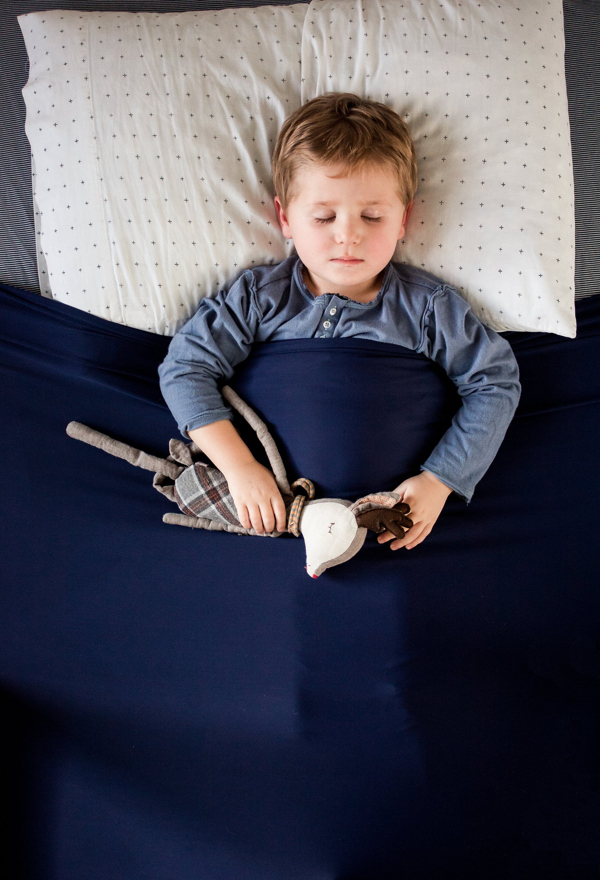 Boy sleeping under cozy compression bedsheet with DTP technology.