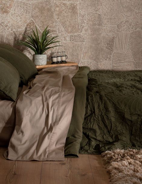 Bohemian bedroom featuring refreshing olive green quilt with quality embroidery throughout.