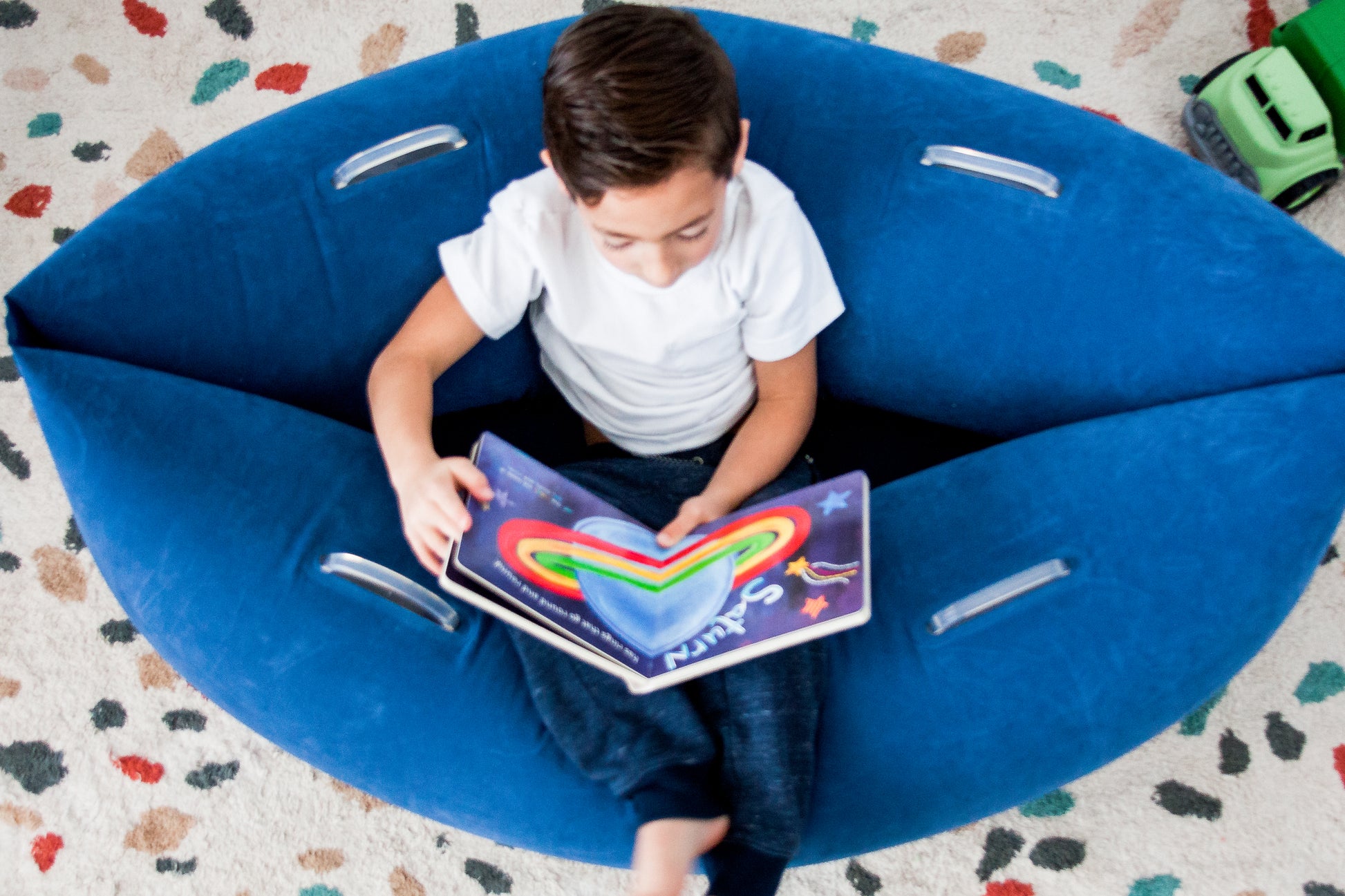 Young boy reading and relaxing in inflatable Cozy Canoe with DTP technology.