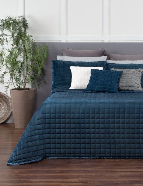 Contemporary bedroom featuring Luxus Laredo Velvet Quilt Set, in blue, with boxed embroidery and satin edge.