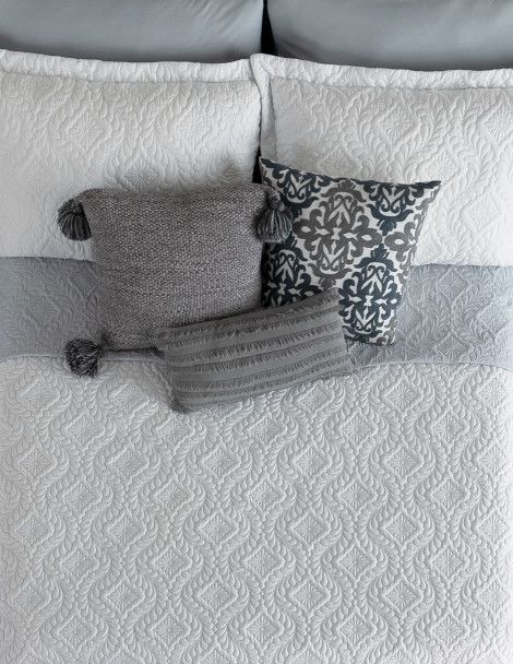 Adult bed set featuring luxuriously embroidered white quilt with 3D effect.