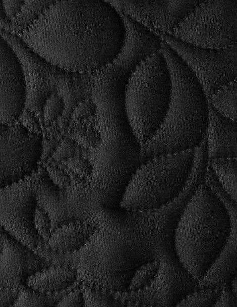 Detailed view of 3D quilt black reverse with embroidered floral design.