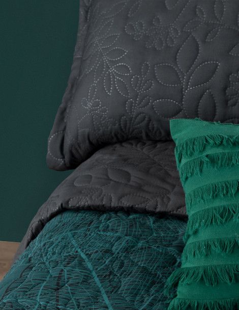 Close up 3D green and black quilt set with foliage design and coordinating pillows.