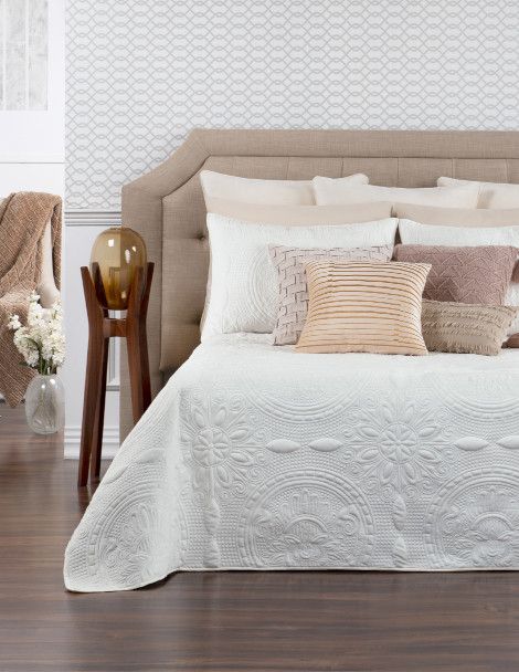 Traditional bedroom featuring luxurious white quilt with 3D ornamental embroidery and velvet finish.