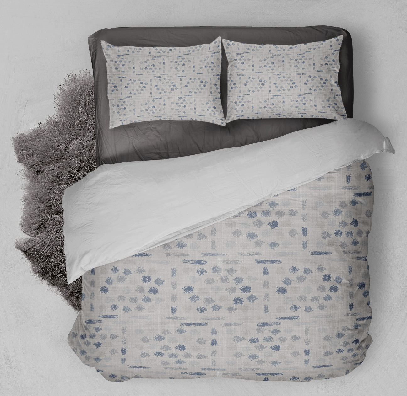 Tidy bed displaying printed gray comforter set with decorative smudge pattern.