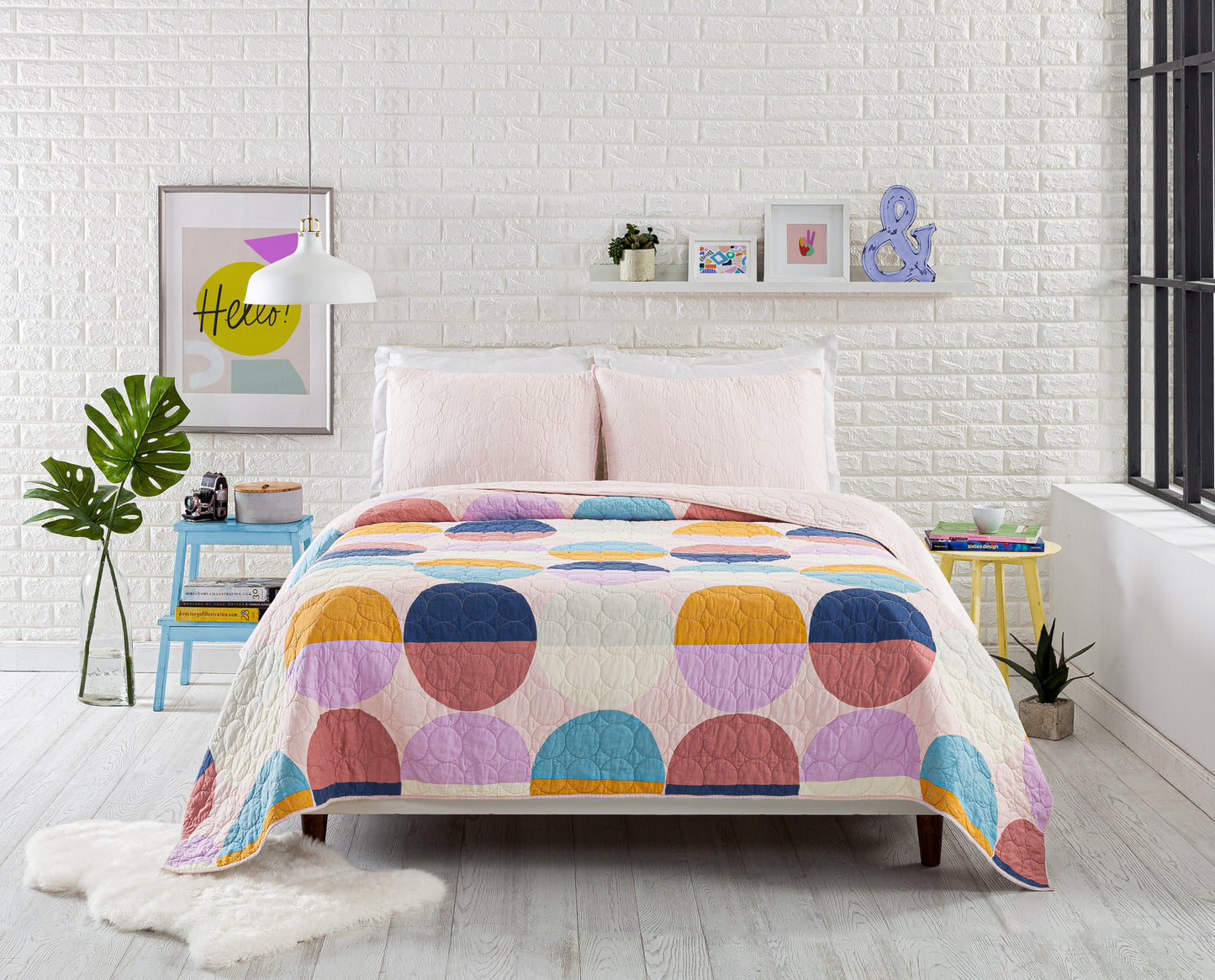 Industrial style bedroom featuring quilt set with color blocked circle design.