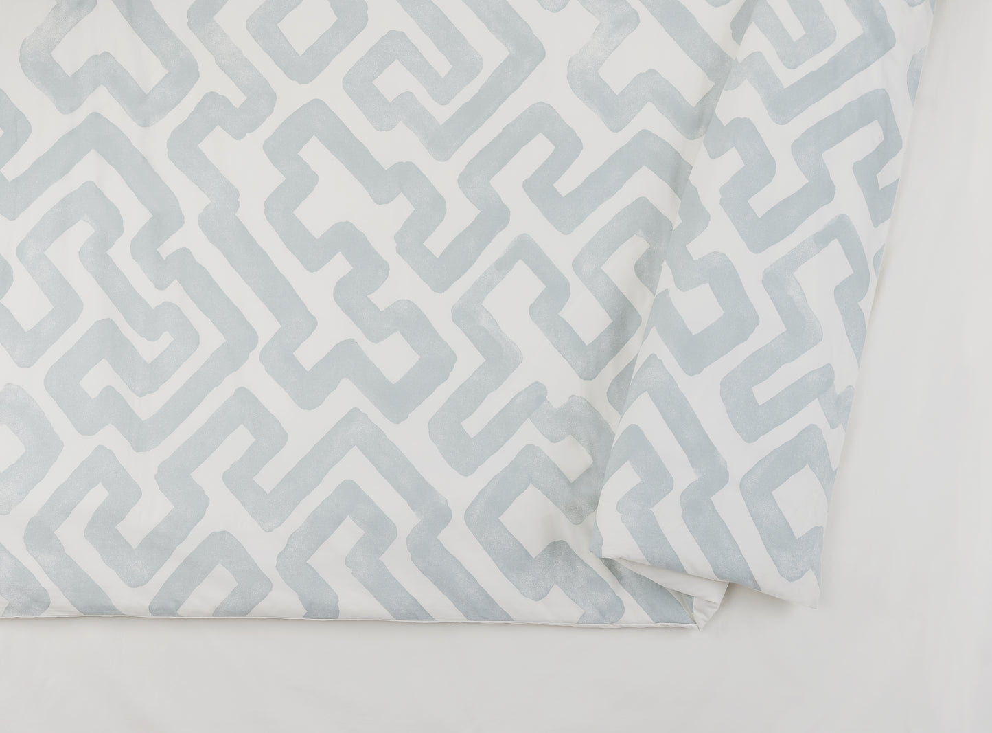 Close up of Lemieux Et Cie duvet cover with gray and ivory puzzle pattern.