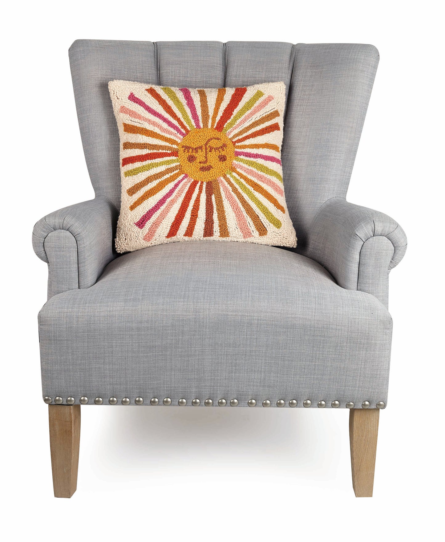 Cat Coq retro style sun throw pillow with multi-colored rays against gray upholstered chair.