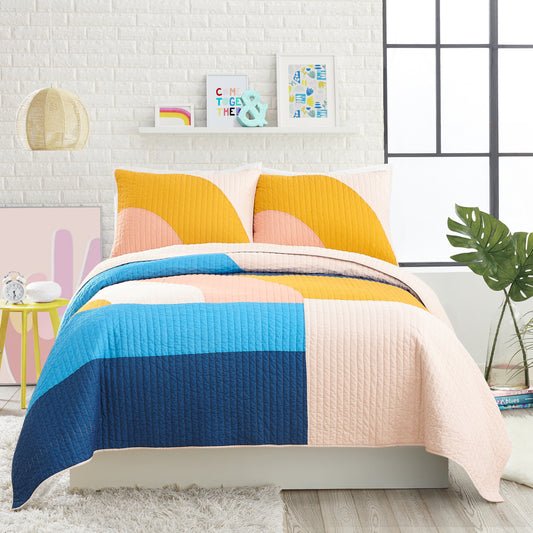 Modern style bedroom featuring modern quilt set with colorful, connecting shapes in yellow, blue and pink.