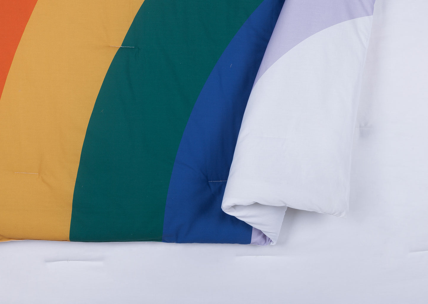 Close up of rainbow design comforter by Ampersand.